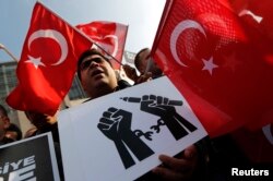 FILE - Supporters of the Gulen movement are seen waving Turkish flags at a rally outside the Justice Palace in Istanbul, Dec. 19, 2014. Since last year's coup attempt, thousands of Gulen supporters in Turkey have been arrested, with the rest pushed into a virtual underground.