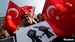 FILE - Supporters of the Gulen movement wave Turkish flags as they gather outside the Justice Palace in Istanbul, Dec. 19, 2014.