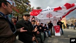 In this March 15, 2017 photo, supporters of Turkey's main opposition Republican People's Party, or CHP, sit at their tent promoting the 'NO' vote for the upcoming referendum, in central Istanbul. 