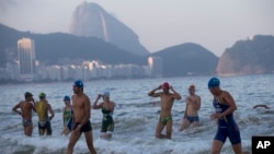 Triathletes leave the water after swimming in the Copacabana beach during training ahead of the Triathlon Olympic Qualifier event, in Rio de Janeiro, Brazil, July 31, 2015. 