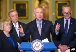 FILE - Senate Minority Leader Harry Reid of Nevada, center, talks to reporters on Capitol Hill in Washington, March 1, 2016.