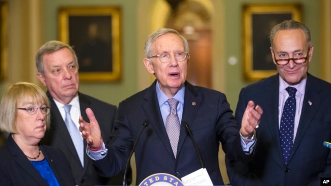 FILE - Senate Minority Leader Harry Reid of Nevada, center, talks to reporters on Capitol Hill in Washington, March 1, 2016.