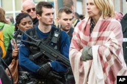 A police officer stands guard as people are evacuated from Brussels airport, after explosions rocked the facility in Brussels, Belgium, March 22, 2016.