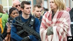 A police officer stands guard as people are evacuated from Brussels airport, after explosions rocked the facility in Brussels, Belgium, March 22, 2016.