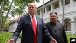도널드 트럼프(왼쪽) 미국 대통령이 지난 12일 싱가포르 카펠라 호텔에서 김정은 북한 국무위원장과 회담 후 취재진 질문에 답하고 있다. 
