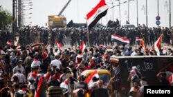 Pasukan keamanan Irak melakukan pengamanan ketat saat berlangsung demonstrasi anti pemerintah di Baghdad, hari Jumat (25/10). 