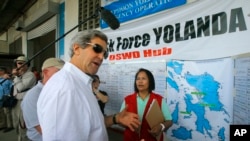 U.S. Secretary of State John Kerry visits a relief distribution center during a tour of the damage from Typhoon Haiyan in Tacloban, Philippines, Dec. 18, 2013.