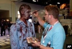 FILE - A zombie has his makeup done at AMC's "Walking Dead" booth before Preview Night at Comic-Con International, held at the San Diego Convention Center, July 8, 2015.