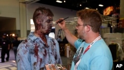 FILE - A zombie has his makeup done at AMC's "Walking Dead" booth before Preview Night at Comic-Con International, held at the San Diego Convention Center, July 8, 2015.