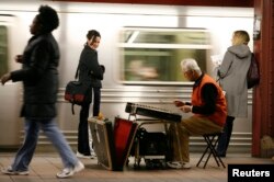 Pengamen ini memainkan alat musik tradisional China di stasiun kereta bawah tanah New York.