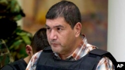 FILE - Ivan Velazquez-Caballero, of Nuevo Laredo, Mexico, the alleged leader of the Zetas cartel in Mexico known as "El Taliban," is escorted to a media presentation in Mexico City, Sept. 27, 2012.