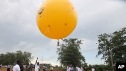 Students use a balloon to launch Deployable CanSat, a soda-can sized model of a satellite, All Nations University, Koforidua, Ghana, May 15, 2013.