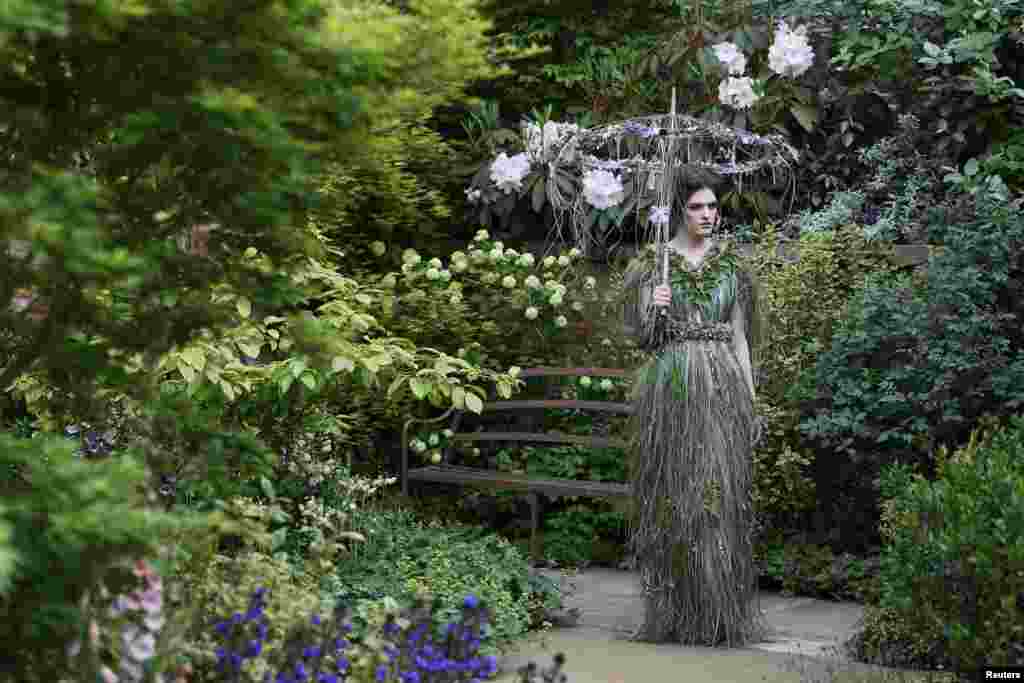 A women wearing a dress of fresh flowers designed by Zita Elze poses for photographers in the M & A Centenary Garden during media day at the Chelsea Flower Show in London.