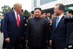 Presiden AS Donald Trump, pemimpin Korut Kim Jong Un dan Presiden Korsel Moon Jae-in di zona demiliterisasi (DMZ), Minggu (30/6).