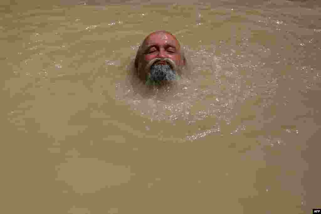 오르단강 서안 도시 예리코의 예수 세례터에서, 세르비아 정교회 순례객이 강물에 몸을 담그고 있다.