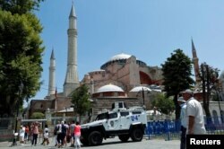 Tourists enter the Byzantine-era monument of Hagia Sophia as they pass by an armoured police vehicle in the Old City of Istanbul, Turkey, July 13, 2016.
