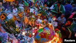 People pay tribute, lay flowers outside house where former South African President Nelson Mandela resided, Johanesburg, Dec. 7, 2013.