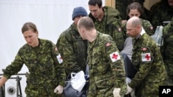 Canadian Forces medical members carry a stretcher out of the medical center to a vehicle with one of the three survivors from the First Air flight 6560 plane crash in Resolute Bay, Nunavut, August 21, 2011