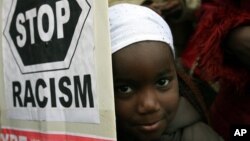 Пятилетняя девочка из Нигерии держит плакат во время демонстрации иммигрантов в центре Афин (архивное фото)