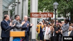 from left to right: NASA Administrator Jim Bridenstine, U.S. Senator Ted Cruz, R-Texas, D.C. Council Chairman Phil Mendelson, and Margot Lee Shetterly, author of the book "Hidden Figures," unveil the "Hidden Figures Way" street sign at a dedication ceremo