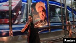 A supporter of moderate cleric Hassan Rowhani celebrates his victory in Iran's presidential election along a street in Tehran, June 16, 2013.