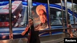 A supporter of moderate cleric Hassan Rohani celebrates his victory in Iran's presidential election along a street in Tehran, June 16, 2013.