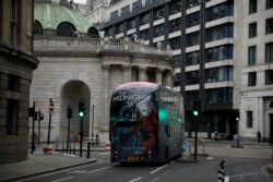 A bus drives through the City of London financial district in London, Jan. 5, 2021, on the first morning of England entering a third national lockdown since the coronavirus outbreak began.