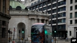 A bus drives through the City of London financial district in London, Jan. 5, 2021, on the first morning of England entering a third national lockdown since the coronavirus outbreak began. 