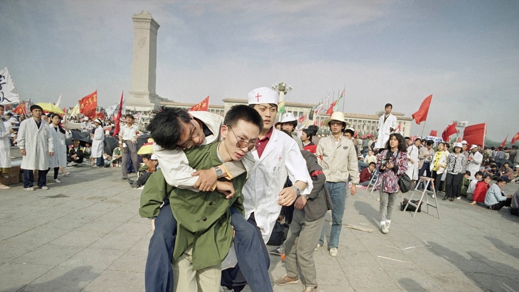 1989年5月16日，一名救护人员将一名绝食晕倒的北京大学生送出天安门广场。