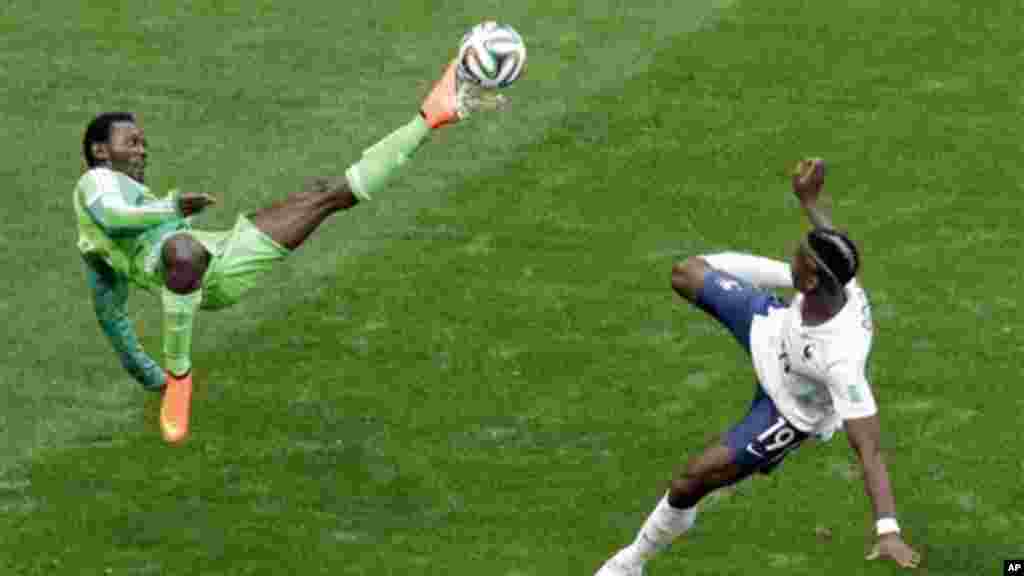 Nigeria's Juwon Oshaniwa and France's Paul Pogba challenge for the ball.