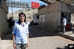 FILE - Nikki Haley, the U.S. ambassador to the U.N., poses for a photo during a visit at the Reyhanli border crossing with Syria, near Hatay, southern Turkey, May 24, 2017.