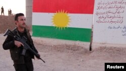 Seorang pejuang Kurdi Peshmerga menaiki berjalan di barat daya Kirkuk, Irak, 13 Oktober 2017.