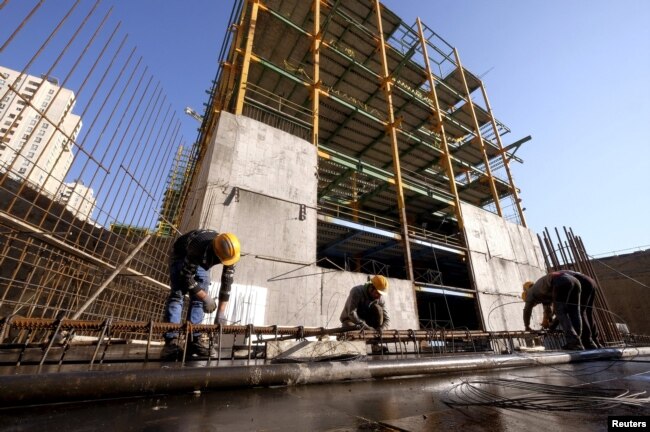 ARCHIVO-Obreros trabajan en un sitio de construcción en Teherán, Irán, el 20 de enero de 2016. El presidente iraní, Hassan Rouhani, dijo el 8 de mayo de 2018 que Estados Unidos no podría perjudicar a la economía iraní volviendo a imponer sanciones relacionadas con la energía nuclear.