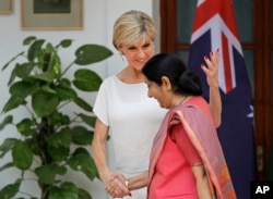 FILE - Australian Foreign Minister Julie Bishop, left, talks with her Indian counterpart Sushma Swaraj as they leave for a delegation level meeting in New Delhi, India, July 18, 2017. Australia is contributing funds to help Sri Lanka combat its worst outbreak of dengue fever.