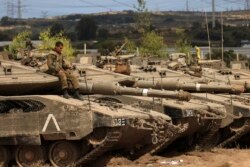 Seorang tentara Israel duduk di atas sebuah tank di tempat pertempuran dekat perbatasan dengan Jalur Gaza, Israel selatan, setelah gencatan senjata diberlakukan. (Foto: AP)