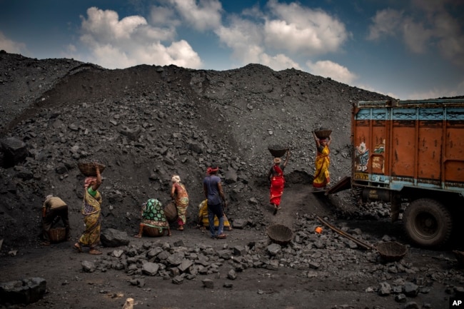 FILE - Indian laborers load coal into a truck in Dhanbad, an eastern Indian city in Jharkhand state, Friday, Sept. 24, 2021. (AP Photo/Altaf Qadri)