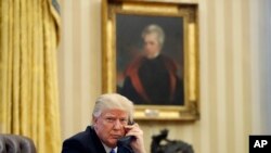 FILE - In this Saturday, Jan. 28, 2017 file photo, President Donald Trump speaks on the telephone with Australian Prime Minister Malcolm Turnbull in the Oval Office of the White House in Washington.