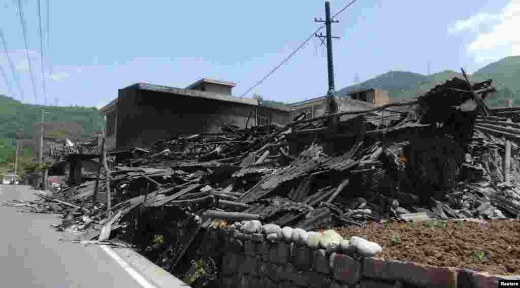 Collapsed houses are seen after an earthquake of 6.6 magnitude, on the side of a road leading from Ya&#39;an city to Luzhou county, in Ya&#39;an, Sichuan province, Apr. 20, 2013. 