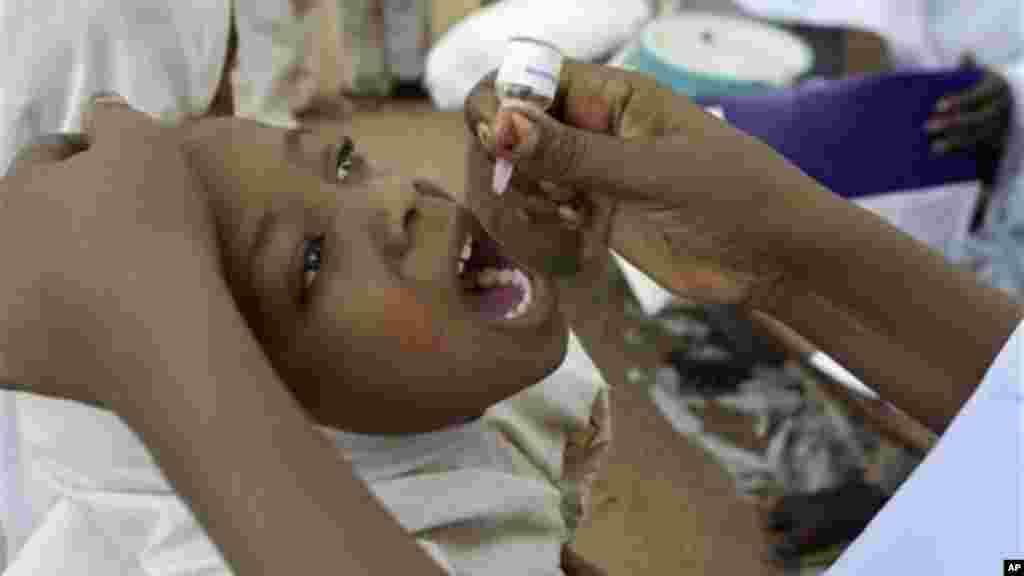 A health worker gives a child an oral polio vaccine in Kano, Nigeria.