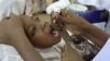 FILE - A health worker gives a child an oral polio vaccine in Kano, Nigeria.