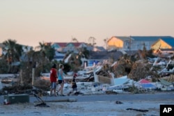 Personas caminan entre las ruinas de México Beach, luego del huracán Michael, el 13 de octubre de 2018.