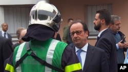 El presidente francés, Francois Hollande, habló con personal de emergencia tras llegar al lugar de la toma de rehenes, en Normandía, Francia, el martes, 26 de julio de 2016.
