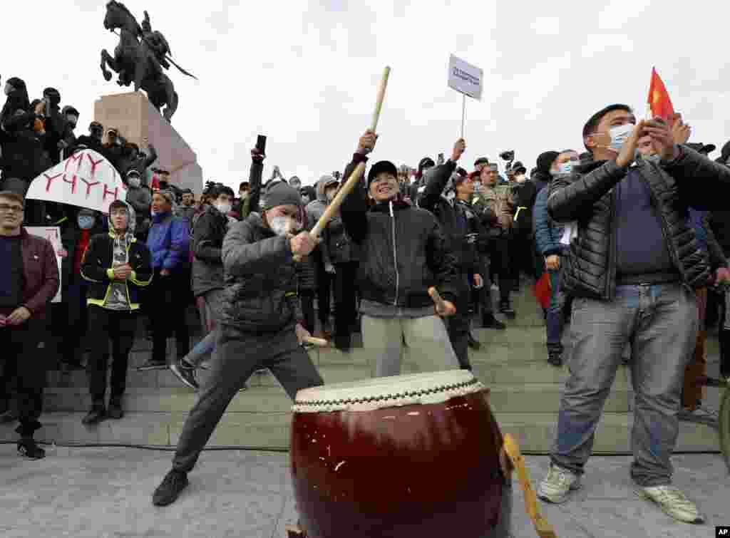 Supporters of former President Almazbek Atambayev bang on the drum during a rally on the central square in Bishkek, Kyrgyzstan, Friday, Oct. 9, 2020. Sooronbai Jeenbekov, the embattled president of Kyrgyzstan, has moved to end the political turmoil that f