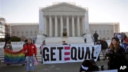 Para pengunjuk rasa berdiri di depan gedung Mahkamah Agung Amerika, di mana para hakim agung Amerika akan segera memulai pembahasan terkait referendum di California yang melarang pernikahan sesama jenis, hari ini (26/3). 
