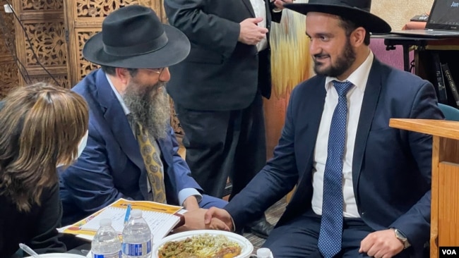 Yehuda Gerami, chief rabbi in Iran, shakes hands with Rabbi Sholom Deitsch, head of Chabad Lubavitch of Northern Virginia, after giving a talk at the Fairfax, Virginia, synagogue, Nov. 14, 2021 (Michael Lipin/VOA)