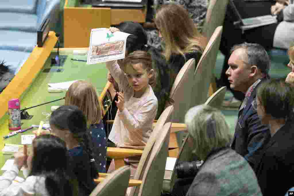 A young member of the Polish delegation shows off a drawing she made during the 30th anniversary of the adoption of the Convention on the Rights of the Child at United Nations headquarters in New York.