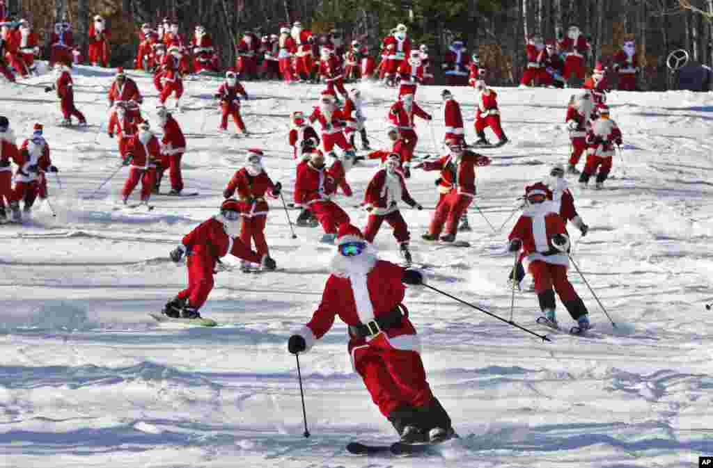 Pemain ski dan snowboard&nbsp;berpakaian Sinterklas bermain ski beramai-ramai di resor ski Sunday River, di Newry, Maine, USA.