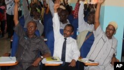 Somali MPs raise their hands during session to impeach Prime Minister Abdi Farah Shirdon, in Mogadishu, Somalia, Dec. 2, 2013.