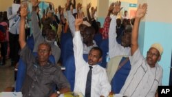 Somali MPs raise their hands during session to impeach Prime Minister Abdi Farah Shirdon, in Mogadishu, Somalia, Dec. 2, 2013.
