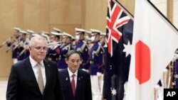 Perdana Menteri Australia Scott Morrison, kiri, dengan mitranya dari Jepang, Yoshihide Suga meninjau seorang penjaga kehormatan selama upacara menjelang pertemuan di kediaman resmi Suga di Tokyo pada Selasa, 17 November 2020. (Foto: Kiyoshi Ota via AP)